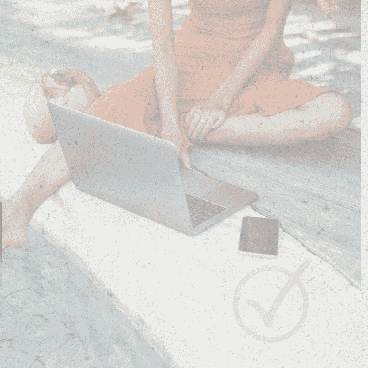 Woman in orange dress typing on laptop, phone nearby, faded with checkmark overlay.